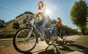 Zwei Frauen und ein Mann fahren mit dem Fahrrad durch die Stadt.