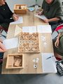 4 Personen sitzen an einem Tisch und probieren sich an einem kognitiven Trainingsspiel.