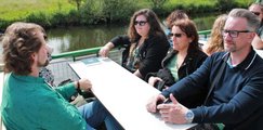 Foto: Vier Personen sitzen anlässlich der Jubiläumsfeier dem Boot an einem Tisch gegenüber. 