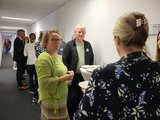 Foto: Mehrere Teilnehmende stehen im Flur und tauschen sich aus