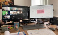 Fotografiert wurde ein Schreibtisch mit zwei Computerbildschirmen. Auf dem linken Bildschirm ist die Videokonferenz zu sehen, auf dem rechten Bildschirm werden die Rückmeldungen der Austauschrunde in einer Mindmap gesammelt.