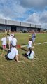 Foto: Acht Kinder und ihr Betreuer beim Spiel auf einer Wiese. 