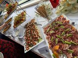 Foto vom Buffet mit appetitlich angerichteten Platten und Schüsseln mit Speisen, wie Tomate-Mozarella-Spieße, Wurst, Obst etc.  