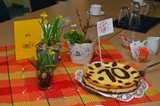 Gedeckter Kaffeetisch mit Blumen und Kuchen mit der Zahl 10 und Fähnchen 