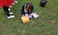 Eine Schülerin schreibt ihren Wunsch auf ein Stück Papier in Kleeblattform.