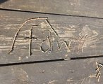 Auf einer Holzoberfläche wurde das FAW-Logo aus kleinen Stöcken gelegt.