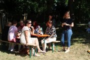 Impressionen vom Sommerfest 2025 der faw Cottbus Foto: faw-Mitarbeiter*innen sitzen mit Getränken an einem Tisch auf einer Wiese unter einem Baum.