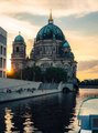 Foto: Berliner Gebäude in der untergehenden Sonne vom Fluss aus fotografiert.