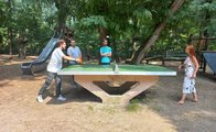 Zwei Azubis spielen Tischtennis. Zwei weitere Azubis stehen hinter der Tischtennisplatte und schauen zu.