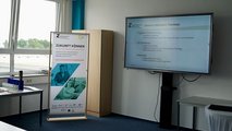40 Jahre faw und 25 Jahre faw in Cottbus Foto vom Raum des Zukunftszentrum. Rechts ein digitales Whiteboard mit einer Präsentation, links ein passender Aufsteller.