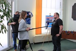 Moderatorin mit Mikrofon und Kameramann im Interview mit Mitarbeiter von Next Level in Cottbus
