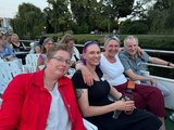 Foto: Einige Jubilar*innen blicken lächelnd auf dem Oberdeck des Schiffes sitzend, in die Kamera.