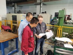 Mitarbeiter des AZ Zwickau zeigt zwei chinesischen Kollegen Pläne. 