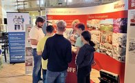 Drei Schüler und eine Schülerin stehen am Stand von Elektro Beckhoff und unterhalten sich mit einem Mitarbeiter und einer Mitarbeiterin.