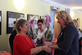 Mehrere Frauen übergeben Orchideen als Geschenke. 