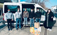 Galeriebild: Sechs Personen stehen mit Sachspenden in Kartons vor einem Transporter