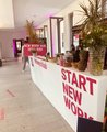 Fotografiert wurde der Eingang des HR Campus Mitteldeutschland. Auf einem weißen Tresen stehen Pflanzen, Getränke und eine Ananas.