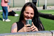 Sommerfest 2026 Eine Mitarbeiterin lächelt in die Kamera und macht gleichzeitig ein Foto mit ihrem Handy.