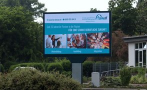 Dargestellt ist die digitale Werbetafel in Bitterfeld-Wolfen, auf der Werbung der FAW geschaltet ist.