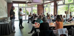 Foto: Viele Menschen sitzen im Restaurant und es wird eine Rede gehalten.