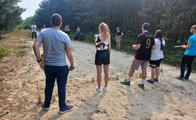 Auf einer Sandfläche spielen die Auszubildenden Wikinger-Schach. Rechts und links ist der Wald zu sehen.