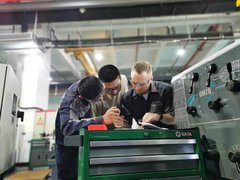 Mitarbeiter des AZ Zwickau mit zwei chinesischen Kollegen samt Schutzbrillen am Arbeitstisch.