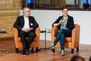 Thorsten Matusch von Cleanteam Berlin und Corina Scholz von der FAW Berlin/Zukunftszentrum Berlin im Gespräch sitzend auf der Bühne.