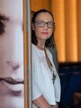 Fachtagung Depression Nahaufnahme einer Frau, die an der Wand gelehnt aus dem Kinosaal blickt.