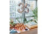 Foto: mit Luftballons 3 und 5 als Zahl und darunter Torte und Häppchen auf dem Buffet