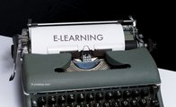 Alte Schreibmaschine, in der ein Blatt mit der Aufschrift e-learning steckt.