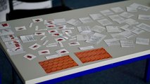 40 Jahre faw und 25 Jahre faw in Cottbus Foto vom Wissenstest für Besucher*innen: Auf einem Tisch liegen viele kleine Notizzettel und Aufgabenstellungen.