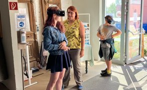 Eine Schülerin und ein Schüler sehen sich mit VR-Brillen Berufe an. Zwischen ihnen steht eine Mitarbeiterin der FAW.