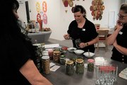 3 Frauen probieren sich an der Teestation und mischen sich mit verschiedenen Kräutern eine eigene Teesorte
