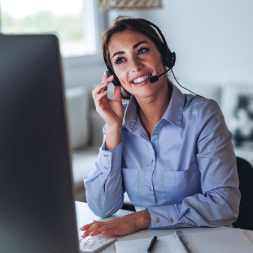 Eine Frau mit Headset nimmt am PC an einem Onlinekurs teil: Symbolbild Online weiterbilden in der faw