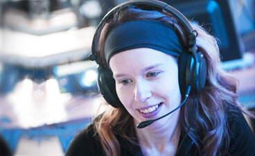 Junge Frau mit Headset am PC.