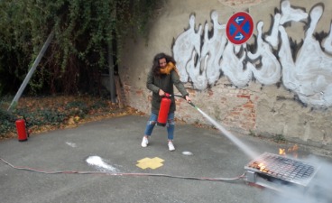 Teaserbild: Eine Frau löscht ein Feuer mit einem Feuerlöscher zu Übungszwecken