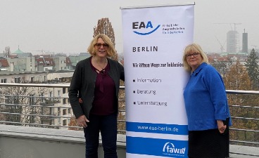 Frau Unfried und Frau Pfennig-Engel stehen neben dem Roll-Up der EAA