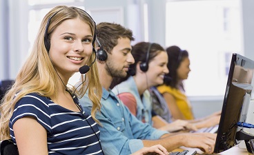 Teaserbild: Vier Personen sitzen mit Kopfhörern an Computern