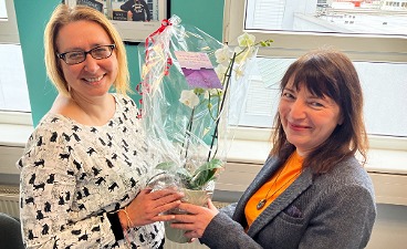 Ivonne Bellen überreicht Simone Karnatz zum Dienstjubiläum eine Orchidee.