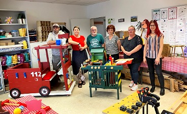 Gruppenfoto in der Werkstatt mit MdL Nadine Graßmel, faw-Team und AGH-Teilnehmenden am Standort Luckau.