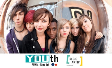 Sechs Jugendliche stehen vor einer Wand mit Graffiti und schauen in die Kamera. Darunter ist ein weißer Kasten, in dem die Logos von "YOUthPoints – Come In!" und "REGIO AKTIV Salzlandkreis" abgebildet sind.