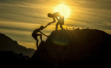 Teaserbild: Ein Junge hilft einem anderen den Berg hinauf