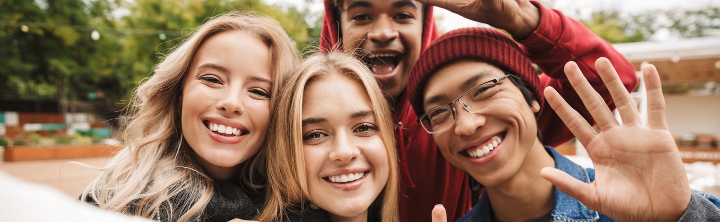 Eine Gruppe junger Menschen lächelt in die Kamera. Symbolbild.