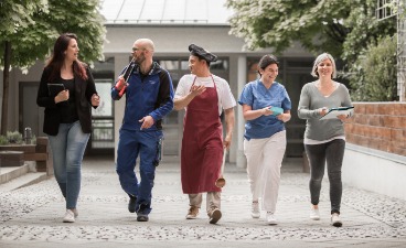 Foto: Fünf Personen mit unterschiedlicher Berufskleidung