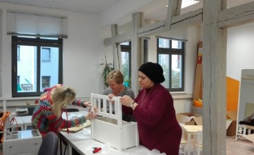 Teilnehmende gestalten das Cafe WunDer Das Bild zeigt Teilnehmende und Mitarbeitende bei der Gestaltung der Räumlichkeiten des Cafe WunDer
