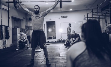 Challenge me Zu sehen ist ein Mann, der im Fitnessraum mit einer Hantel trainiert