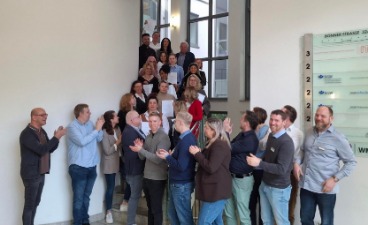 Gruppenfoto der Teilnehmer*innen der Teilqualifikation Verkäufer*in im Treppenhaus. 