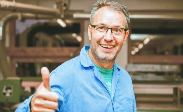 Langzeitarbeitslosen eine Perspektive bieten! Mann im blauen Hemd zeigt Daumen hoch