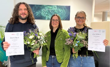 Foto von der Reha-Zertifikatsübergabe: Die drei Reha-Fachkräfte mit ihren Zertifikaten und Blumensträußen in den Händen. 
