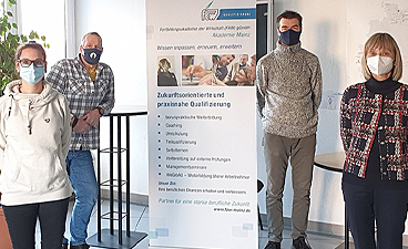 Vier Personen mit Mund-Nasen-Schutzmaske bei der Zertifikatsübergabe